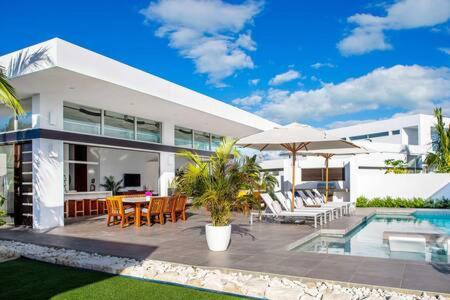 a house with a patio with a table and chairs at TOP Rated Private Villa with Pool, Beach Access, Resort Amenities - White Villas v10 in Providenciales