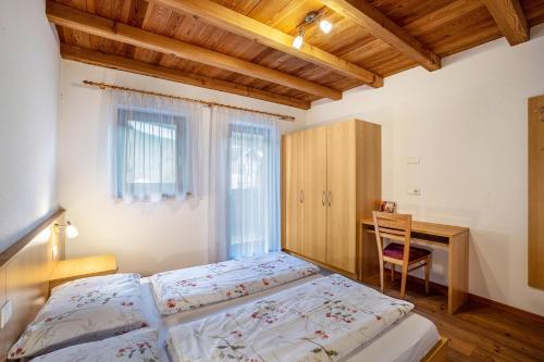a bedroom with two beds and a desk and a table at Speckign Apartment 3 in Cadipietra