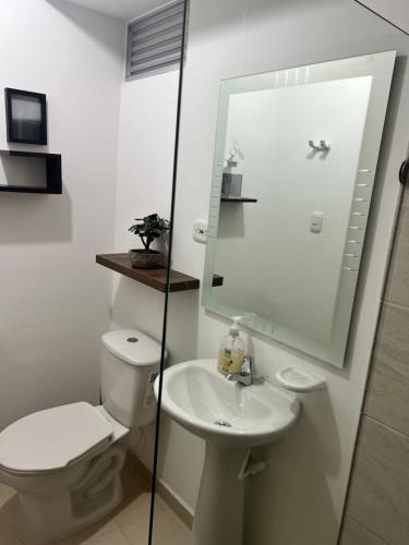 a white bathroom with a toilet and a sink at Moderno apartamento con vista inigualable in Dosquebradas