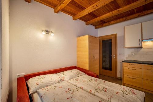 a small bedroom with a bed and a kitchen at Speckign Apartment 3 in Cadipietra