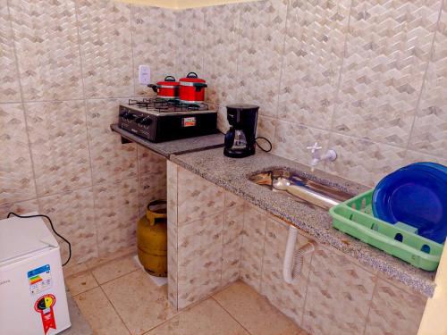 cocina con encimera, fogones y fregadero en Espaço da Cris, en Saquarema