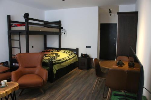 1 dormitorio con litera, mesa y sillas en ski-in/ski-out apartment in Gudauri, en Gudauri