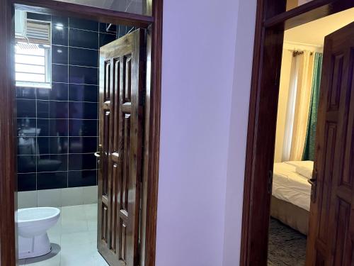 a bathroom with a toilet and a sink in a room at Cyda Pearl Home-Buziga-Munyonyo in Kampala