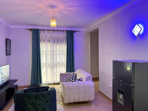 uma sala de estar com um sofá e uma cadeira em Cyda Pearl Home-Buziga-Munyonyo em Kampala