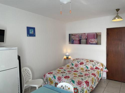 een slaapkamer met een bed en een tafel en een koelkast bij Studio Balaruc-les-Bains, 1 pièce, 2 personnes - FR-1-680-2 in Balaruc-les-Bains