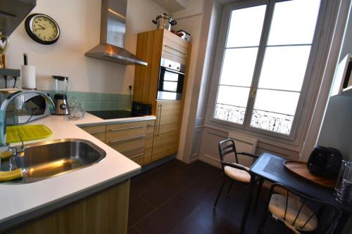 cocina con fregadero y mesa con sillas en Appartement avec vue 180 sur le Lac Léman, en Thonon-les-Bains