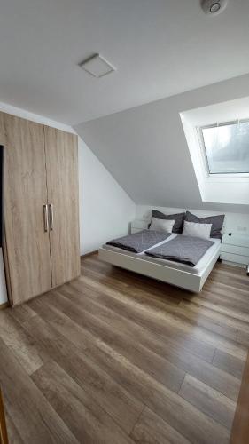 1 dormitorio con 1 cama y suelo de madera en Living Apartment, en Hittisau
