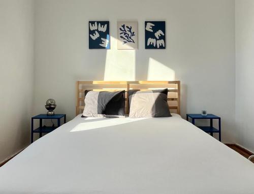 1 dormitorio con 1 cama blanca grande y 2 mesas azules en 2 Bedrooms Apartment In The Heart Of The City, en Craiova