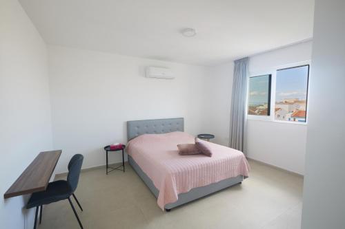 a bedroom with a bed and a desk and a table at Eva Residences- Kapparis in Paralimni