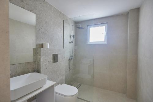 a bathroom with a shower and a toilet and a sink at Eva Residences- Kapparis in Paralimni