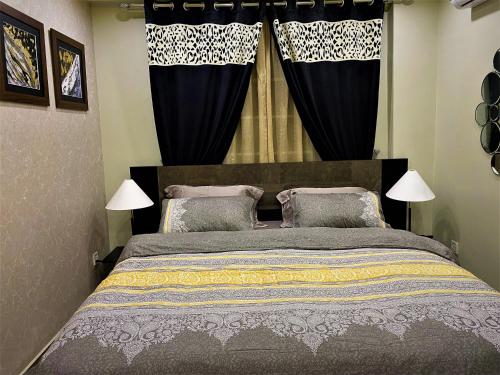 ラホールにある101-NEXT INN Premier Suitesのベッドルーム1室(黒いカーテン付きの大型ベッド1台付)