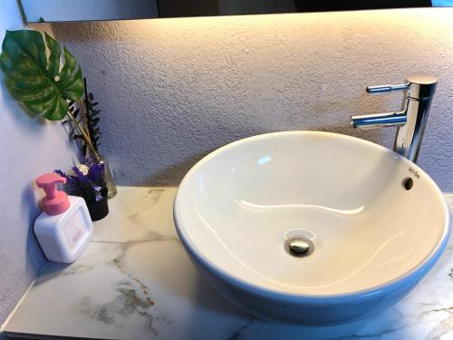 a white sink in a bathroom with a plant at Bao Guesthouse in Seoul