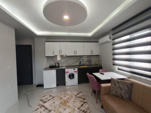 Fatih apart otel في Bostancı: مطبخ وغرفة معيشة مع أريكة وطاولة