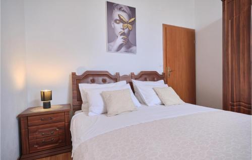 una camera con letto bianco e testiera in legno di Gorgeous Home In Podstrana With House Sea View a Podstrana