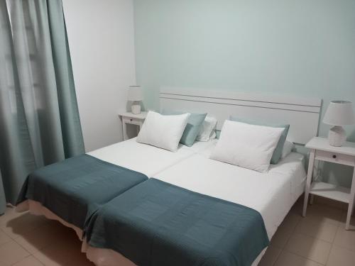 ein Schlafzimmer mit einem großen Bett mit weiß-blauer Bettwäsche in der Unterkunft Cascada de colores in Los Cancajos