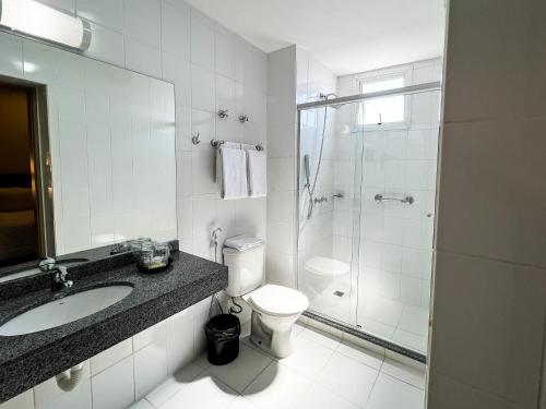 a bathroom with a sink and a toilet and a shower at Master Cosmopolitan Moinhos de Vento in Porto Alegre