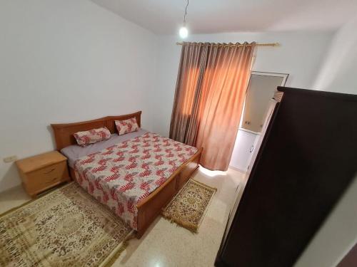 - une petite chambre avec un lit et un miroir dans l'établissement Bienvenue dans votre appartement, à Gabès