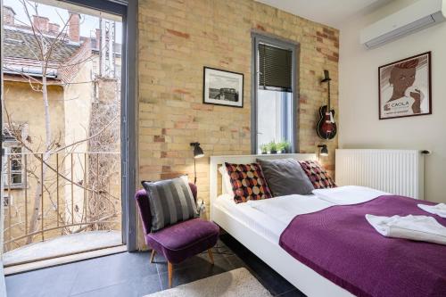 - une chambre avec un lit et un mur en briques dans l'établissement Paulay Deluxe studio, à Budapest