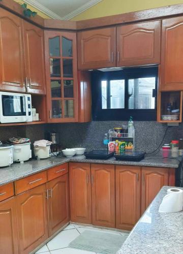 a kitchen with wooden cabinets and a counter top at Sassy's Place in Baguio