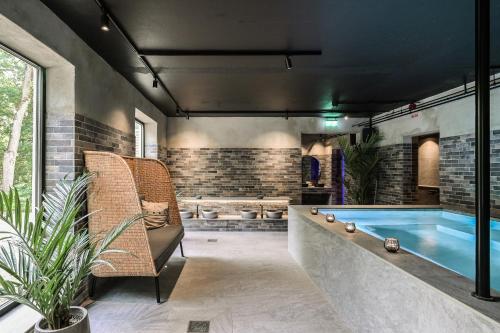 a pool in a room with a couch and a chair at Åsby Hotell in Hallstahammar