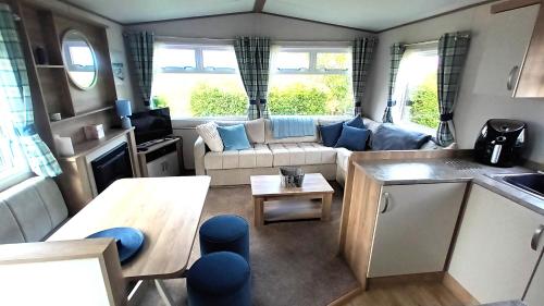 a living room with a couch and a table at Suki - up to 6 berth cabin, new. in Tain