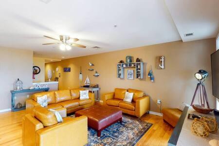 a living room with two couches and a table at Sojourn Penthouse Sanctuary Condo 4 BR in Virginia Beach