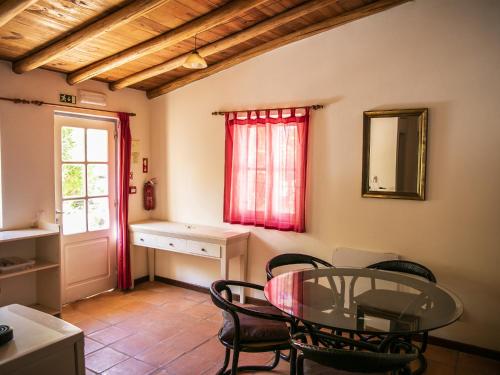 a dining room with a glass table and chairs at Monte Rosa Rural Guesthouse in Lagos
