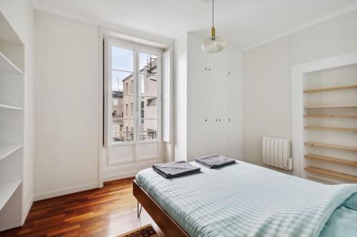 une chambre blanche avec un lit et une fenêtre dans l'établissement Michel Columb elegant - en centre ville, à Nantes