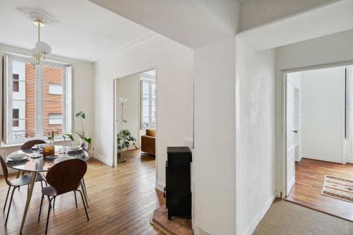 un salon blanc avec une table et des chaises dans l'établissement Michel Columb elegant - en centre ville, à Nantes