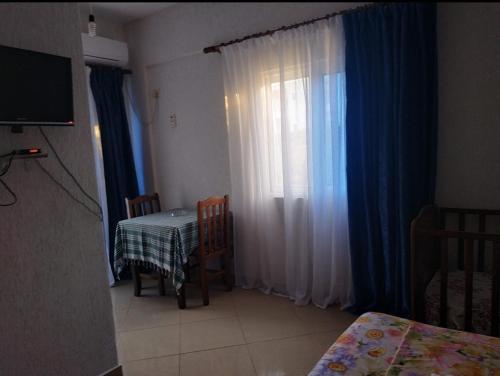 Vila Ester في كساميل: غرفة مع طاولة و نافذة مع ستارة
