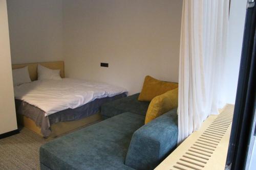 a room with a bed and a couch and a bed and a window at ski-in/ski-out apartment in Bakuriani in Bakuriani