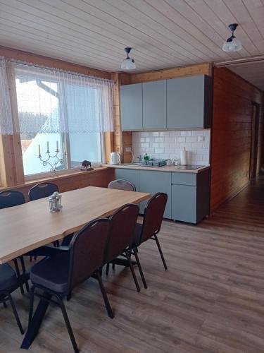 a kitchen with a table and chairs in a room at SZUMI LAS in Białowieża