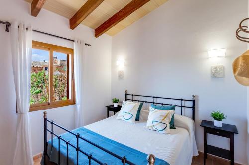 Schlafzimmer mit einem Bett und einem Fenster in der Unterkunft Sa Madoneta in Santanyi