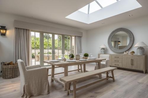 a dining room with a table and a mirror at The Beach House B in Brancaster