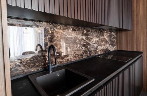 cocina con fregadero y encimera negra en Woodside Apartment en Kopaonik