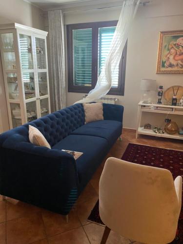 a living room with a blue couch and a chair at Casa Begaj in San Giovanni Valdarno