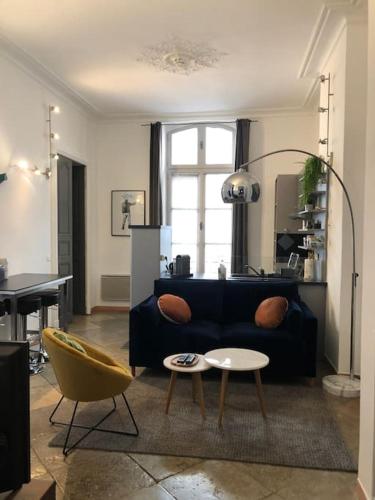 un salon avec un canapé bleu et une table dans l'établissement Appartement P2 de charme - Centre-ville, à Nîmes