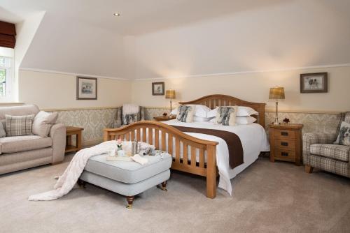 a bedroom with a bed and a couch and a chair at Dryburgh Steading Two in Saint Boswells