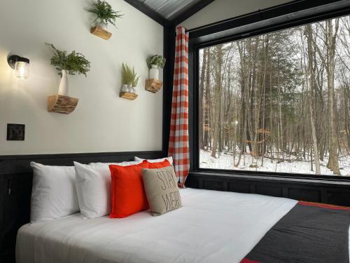 a bedroom with a bed and a large window at Trekker, Treehouses cabins and lodge rooms in Lake George