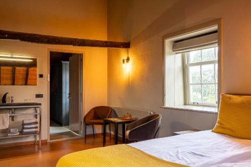 een slaapkamer met een bed, een tafel en een raam bij Den Eijngel bed and breakfast in Boxtel