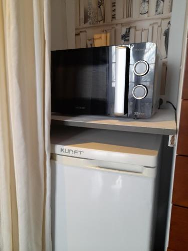 a microwave sitting on top of a refrigerator at Villa Oliva in Sanlúcar la Mayor
