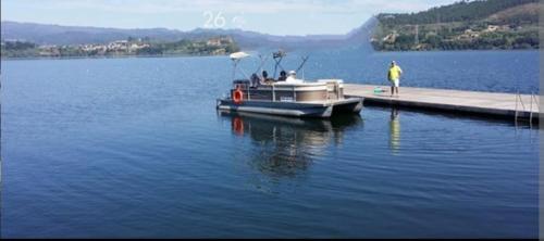 Ein Boot liegt an einem Dock auf einem See. in der Unterkunft CASA DO AVÒ in Castrelo de Miño