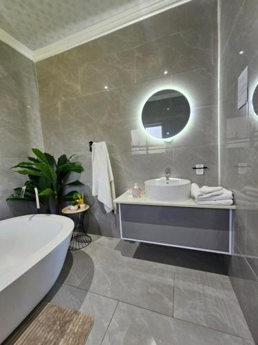 y baño con bañera, lavamanos y bañera. en Caribbean Estates Villa Raiya- Recently Developed! 4 bedroom unit, en Port Edward