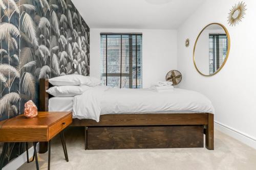 1 dormitorio con 2 camas y espejo en Chic Urban Apartment In Shoreditch 2 bed 2 bath, en Londres
