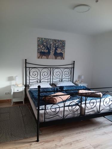 a bedroom with a black bed with a picture on the wall at Apart-Lachmoewe-im-Moewennest-Tossens in Stick