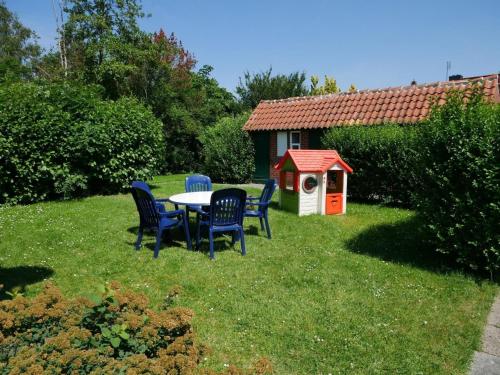 a table and chairs in a yard with a dog house at Apart-Lachmoewe-im-Moewennest-Tossens in Stick