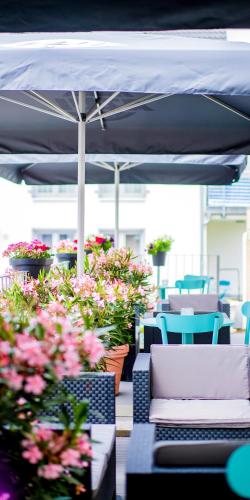 ザンクト・アウグスティンにあるHotel Das Augustinの花が咲くパティオ(テーブル、椅子付)
