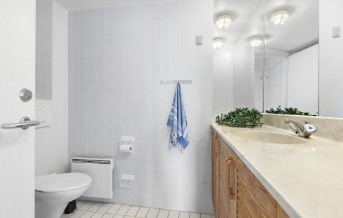 a bathroom with a sink and a toilet and a mirror at 2 Bedroom Stunning Apartment In Fan in Fanø