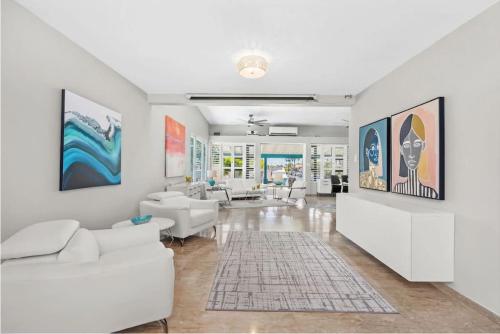a living room with white furniture and paintings on the walls at Waterfront Luxury Home with Dock in San Juan in Pinones