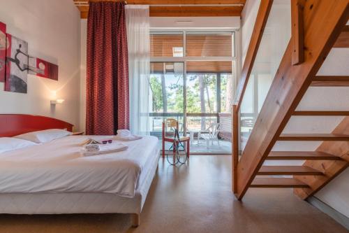 a hotel room with a bed and a staircase at Azureva Ronce les Bains in Ronce-les-Bains